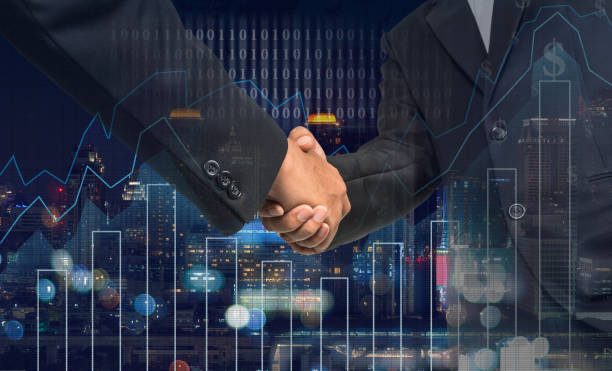 Hand shake between businessman on Trading graph on the cityscape at night and world map background,Business financial concept